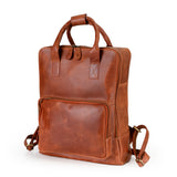 The Bolton Leather Backpack – Tan Brown from Vintage Leather Sydney, featuring two short handles, adjustable shoulder straps, and a large front zip pocket, is displayed in a stylish container with smooth lines against a white background.