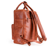 The Bolton Leather Backpack – Tan Brown by Vintage Leather Sydney features sturdy handles, adjustable shoulder straps, and a side zippered pocket for style and practicality, elegantly displayed against a white background.