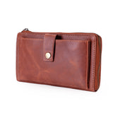 A brown leather zip-around wallet with a front slip pocket and a gold-tone snap button, shown on a plain white background.