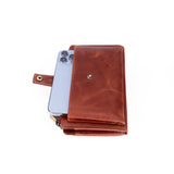 A brown leather wallet case with a snap-button closure and a strap, shown holding a light blue smartphone on a plain white background.
