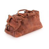 The Leather Duffle Bag Berlin by Vintage Leather Sydney, featuring brown leather, multiple handles, brass hardware, and a zippered side pocket, is shown on a white background—ideal for a stylish and functional travel companion.