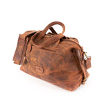 The Leather Duffle Bag Tokyo by Vintage Leather Sydney is shown on a white background, featuring brown leather, handles, a shoulder strap, and a front zipper pocket.