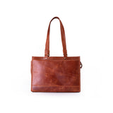 The Leather Handbag Shelby by Vintage Leather Sydney is a brown leather tote with two shoulder straps, a large front pocket, and a simple, elegant design. Shown against a plain white background.