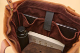 Close-up of the interior compartments of a brown leather or faux-leather bag, showing a dark brown suede-like organizer lining, zipper, elastic strap, and travel items including a bottle, notebook, and wallet.