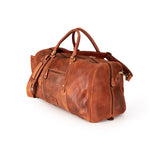 A brown distressed leather duffel bag with dual top handles, a detachable shoulder strap, and brass hardware, shown on a white background.