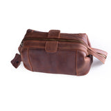 The Leather Travel Toiletry Bag Manchester by Vintage Leather Sydney features brown leather, a zipper closure, side handle, and a small tag—perfect as a stylish dopp kit or cosmetic case for your essentials. Photographed on a white background.