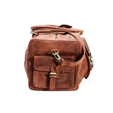 The Leather Duffle Bag - Colorado by Vintage Leather Sydney features brown leather, a front pocket, gold-tone hardware, and a leather tag on the strap. This handmade bag is shown against a white background.