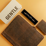 Flat lay of the A4 Leather Compendium Andre by Vintage Leather Sydney, paired with a matching wallet, black pen in a box, and bold GENTLE card—all crafted from premium materials and arranged elegantly on a light tan surface.