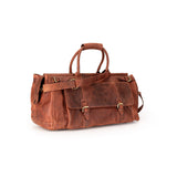 A brown distressed leather duffel bag with double top handles, buckle straps, and a shoulder strap, photographed on a clean white background.