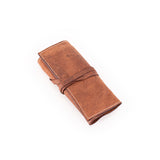 The Leather Artist Roll Zip by Vintage Leather Sydney is a rolled-up brown leather pouch with visible stitching and a wraparound leather tie, shown on a white background.