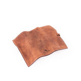A brown Leather Artist Roll Zip by Vintage Leather Sydney, featuring visible texture, lies flat and open on a white surface. A small embossed logo with black text is near the bottom right corner of the leather case.