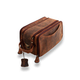 The Leather Travel Toiletry Bag Porter by Vintage Leather Sydney features two zippered compartments, an exterior pocket, a carrying handle, and a leather keychain, shown here in brown on a white background.