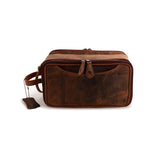 The Leather Travel Toiletry Bag Porter by Vintage Leather Sydney is a rectangular brown bag with a front pocket, zipper closures, and side handle. A leather tag is attached to the handle with a small ball chain for stylish, organized travel.
