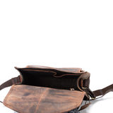The Sedona Leather Cross Body Bag by Vintage Leather is shown open on a white background, revealing its empty main compartment and inner pocket with the flap spread out in front.