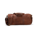 The Leather Duffle Bag - Boston from Vintage Leather features a shoulder strap, two handles, and brass hardware—its simple, classic design makes it a perfect travel bag, seen here against a white background.