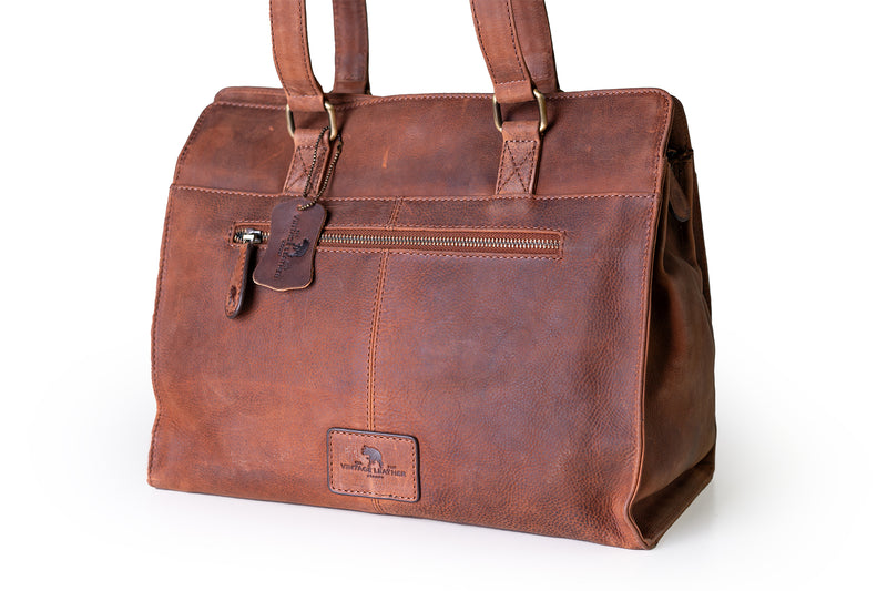 The Leather Handbag Fennel by Vintage Leather Sydney is a brown leather tote with two handles, a front zippered pocket, leather tag, stitched logo patch near the base, and a rustic handcrafted look.