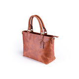 The Leather Small Handbag Lavender by Vintage Leather Sydney is shown on a white background. It features two handles, a matching tag, smooth finish, gold-tone hardware—ideal for those shopping women's handbags online.
