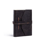 The Personalised Leather Journal Acacia by Vintage Leather, made from full-grain dark brown leather with a wraparound strap and angular front flap, stands closed and upright on a white background.
