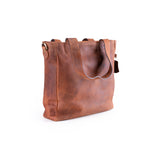 The Leather Work Tote Bag Parsley by Vintage Leather Sydney features a brown leather design with two handles, a minimalist look, and a slightly textured surface, blending timeless style and modern simplicity on a white background.
