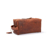 The Vintage Leather Barker Toiletry Bag is a rectangular brown leather bag with zipper closure, side handle, and a tag on the zipper pull—ideal for travel grooming essentials. Shown on a white background.