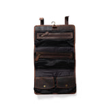 The Leather Hanging Toiletry Bag Rio by Vintage Leather Sydney is open and hanging, showing zippered mesh compartments and snap-button pouches—an essential travel accessory against a white background.
