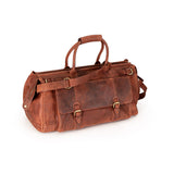 A brown distressed leather duffel bag with double top handles, a detachable shoulder strap, and brass-tone buckle details, shown on a plain white background.